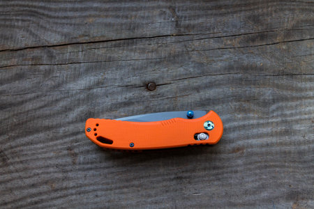 The knife folded on the wooden background. Knife below.