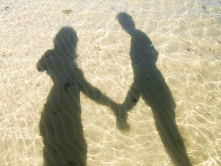 Reflection of two lovers in water. Heart with two loving people.の写真素材