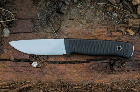 Outdoor knife on wood log. Brown wood. Front view. Sweden knife.