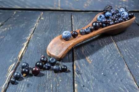 The berries are laid out on a clay spoon. Decoration of forest berries.の写真素材