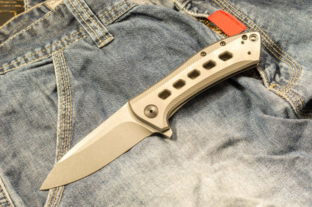 Pocket knife for everyday wearing. Knife with titanium handle. Pocket knife. The front side of the knife. View from above.の写真素材