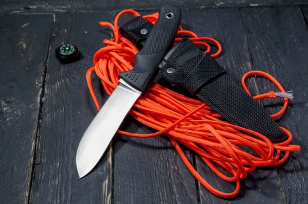 Knife of the German army. A military knife on an orange paracord cord. Black handle.の写真素材