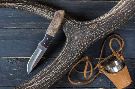 Knife hunter and mug on a black background. Hunting.の写真素材