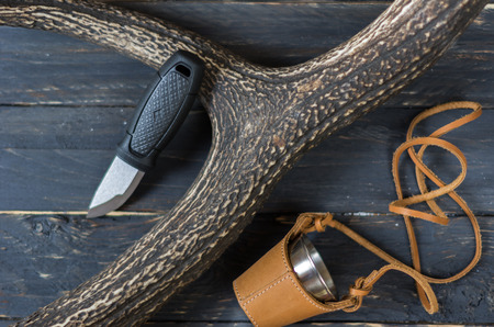 Small hunting knife and a glass in a leather case. The horn of a deer. Hunting.の写真素材