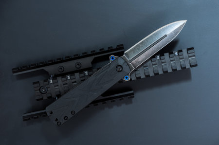 Black knife and black accessories. Black background. Plank for the sight.