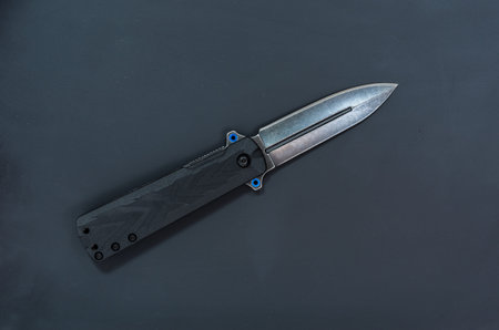 One black knife in the center of the frame on a black background.