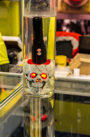 An artificial human skull with red eyes. Tactical flashlight. An artificial human skull with red eyes. Tactical flashlight. Waterproof flashlight.の写真素材