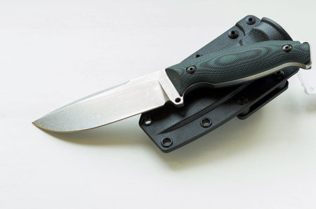 Knife with fixed blade and plastic case. White background.
