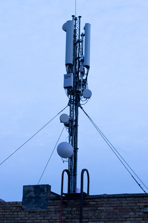 Aerial of mobile communication. Communication transmission. Radio waves. Antenna on the roof of the house.の写真素材