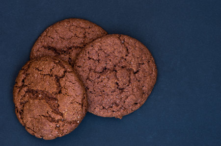 Chocolate gingerbread cookies on a black background. View gingerbread from above. Flat lie.