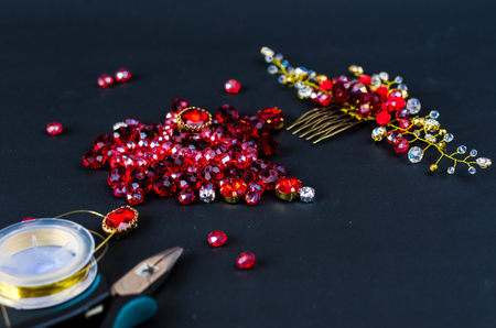 Tools, wire and jewelry made of stones. Front view. Red on black.の写真素材