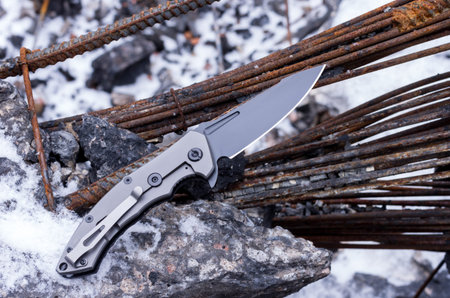 Knife on the background of the ruins and debris. Wire and rust.