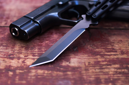 The blade of the knife and the barrel of the gun. Photo at an angle.