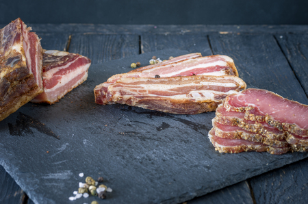 Meat cutting on a slate board. Dark photo. Front view.の写真素材