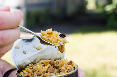 Testing cooked food. Fork in hand. To eat pilau.の写真素材