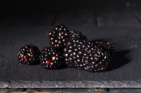 A few blackberries on a black background. Black berries on a black background.の写真素材