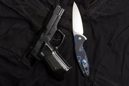 Firearm and knife. Weapons and men's clothing. Top.