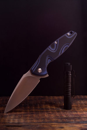 Knife in the unfolded form. The knife is in a hanging position.Vertical frame.