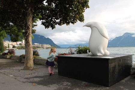 Switzerland, Montreux. September 2013. Little girl and penguin sculpture.のeditorial素材