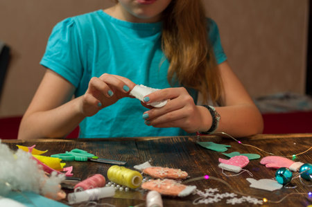 Girl makes toys. Girl getting ready for the holidays. The girl is sewing.