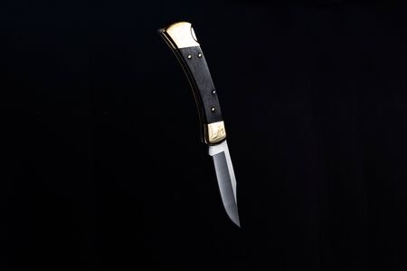 A knife hanging in the air. Knife on a black background.の写真素材