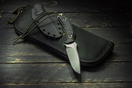 Large clumsy knife on the wallet. Knife and handbag.