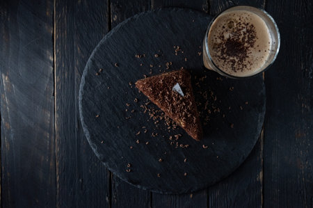 Chocolate cake and coffee with milk top view. Chocolate sprinkle on a cake and coffee. Coffee and...