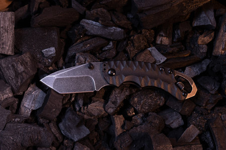A small pocket knife with a tanto blade. Warm and cold light. Top.