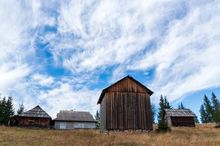 Wooden village houses and blue sky with clouds. Old village houses.の写真素材