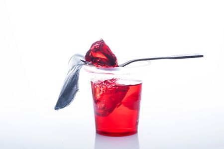 Red jelly in a glass with a spoon. Eat jelly with a spoon.の写真素材