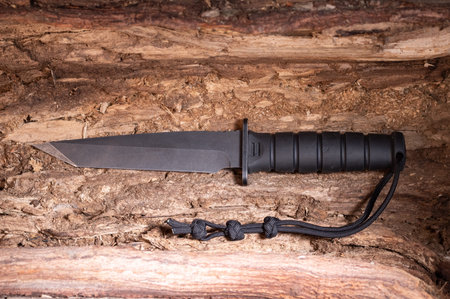 A large army knife of black color with a teapot. Army knife inside a tree. Top.