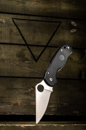 Folding knife on the background of a military box. Unique knife.