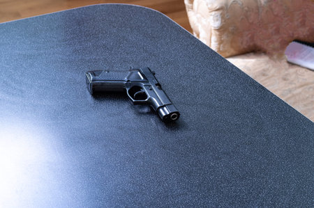Firearm on the home desk. Black gun.