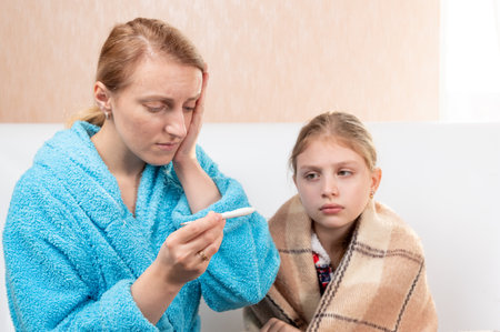 The child has a high temperature. Mom is terrified of the baby's temperature. The child is sick.の写真素材