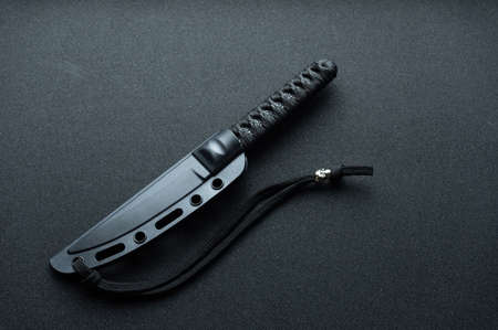 Knife in a plastic sheath. The knife handle is wrapped with paracord. Top.の写真素材