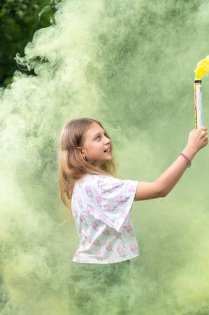 The girl holds and looks at the smoke bomb. The girl looks at the smoke. Vertical frame.の写真素材