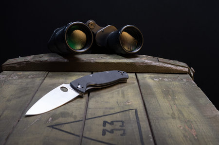 Pocket knife and binoculars. Knife and binoculars on the box.