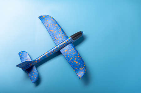 Airplane on a blue background. Toy plane on a blue background. Angle view.の写真素材