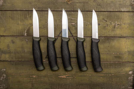 Several identical knives lying in a row. There are many knives on the table.の写真素材