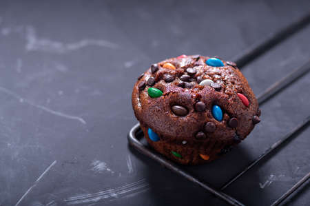 Festive chocolate muffin with colorful sweets. Holiday bun.の写真素材