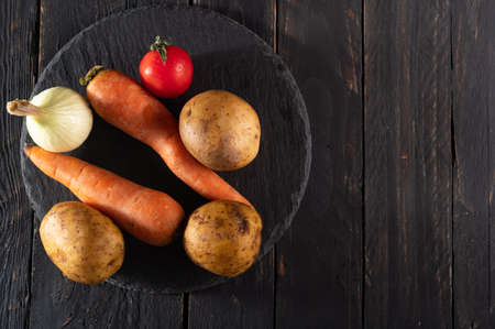 Washed vegetables on the table. Potatoes and onions. Food preparation products. Cooking. View from above.の写真素材