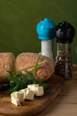 Sliced cheese and bread. Bread with dill and cheese. Ciabatta with spices. Vertical frame.の写真素材