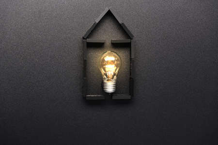 House and glowing lamp. Light in the house. Home electricity.の写真素材