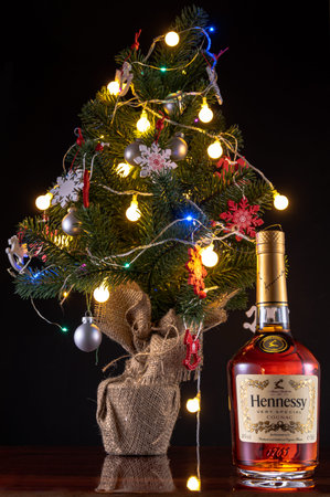 Kyiv, UKR - DEC 20, 2020: Hennessy cognac bottle and Christmas tree. Christmas tree and garlands.のeditorial素材