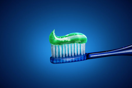 Toothpaste on a brush. Green toothpaste with crystals. Brush and toothpaste. Front view.
