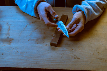 A man checks the sharpness of a knife.Touch the blade of a knife. Run your finger along the blade of...