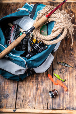 Fishing rod and tackle bag. Preparation for fishing. A bag with a variety of baits and tackle. Vertical frame.の写真素材