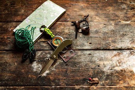 Knife and compass on the table. Knife and tourist items on the table. View from above.の写真素材