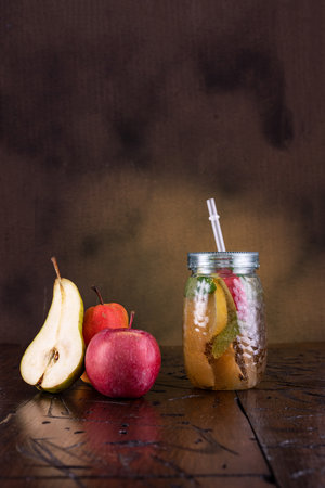 Juice in a jar with a straw. Juice from apples and pears. Fresh fruit juice. Vertical frame.の写真素材
