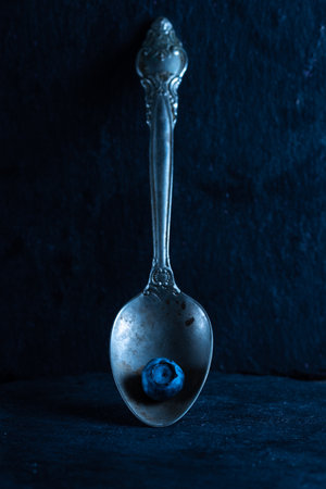 Old spoon with blueberries. Silver spoon and blueberry. Front view.の写真素材